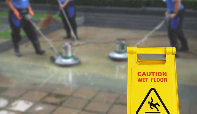 Person cleaning commercial floor with equipment