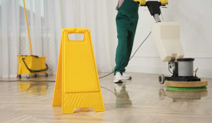 A person cleaning the floor using a cleaning machine