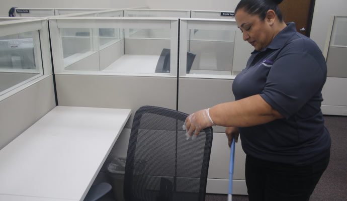 A person cleaning an office cubicle